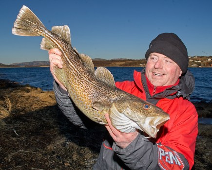 Man holding cod caught from shore
