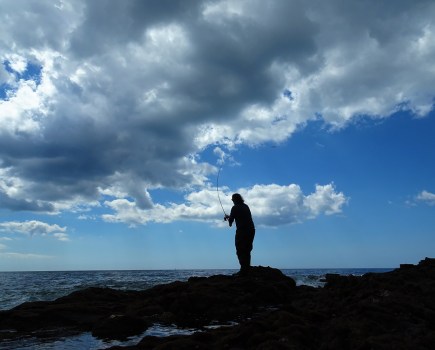 man fishing on beach