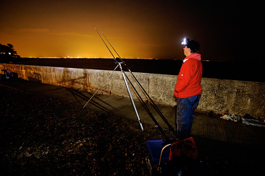 man fishing in autumn at night